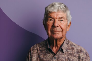 Portrait of an elderly man with grey hair on a purple background
