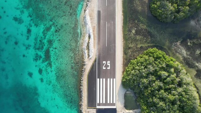 Gran roque airstrip in los roques with turquoise sea and lush greenery, aerial view