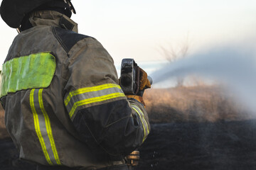 Fireman extinguishing a fire on a field