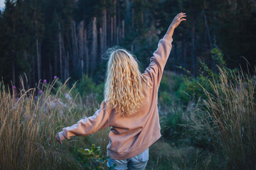 Young Blonde Girl Walking in Dark Forest - 768610684