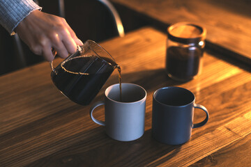 マグカップにコーヒーを注いでいるシーン - obrazy, fototapety, plakaty