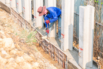 Worker removing concrete formwork of beam retaining walls.