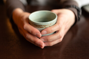 湯飲みを持つ人