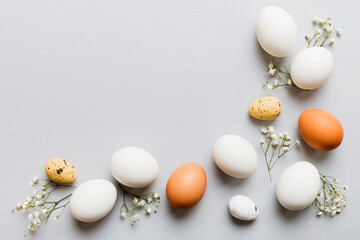 Happy Easter composition. Easter eggs on colored table with gypsophila. Natural dyed colorful eggs...