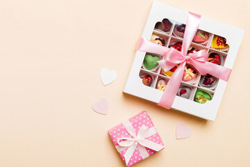 Valentine day composition: sweet candy, with gift boxes with bow and red felt hearts, photo template, background. Top View with copy space
