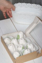 Fototapeta na wymiar A woman puts homemade marshmallows into boxes.