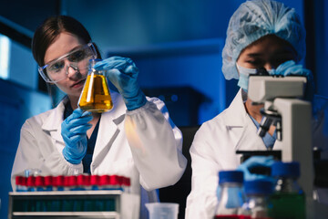Life scientists researching in laboratory. Focused female life science professional pipetting...