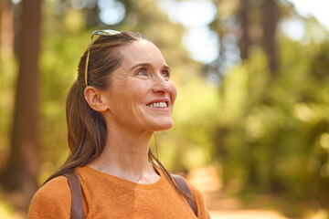 Smiling Senior Woman Relaxing In Nature Hiking Along Trail In Countryside - 768625825