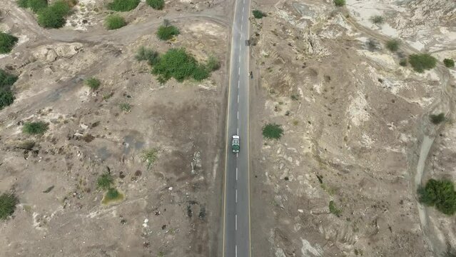 drone flies behind car over street Hingol balochistan dessert