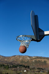 Panier de Basketball avec ballon en extérieur sur fond de ciel bleu. Shoot basketball