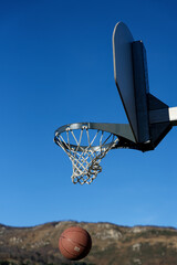 Panier de Basketball avec ballon en extérieur sur fond de ciel bleu. Shoot basketball