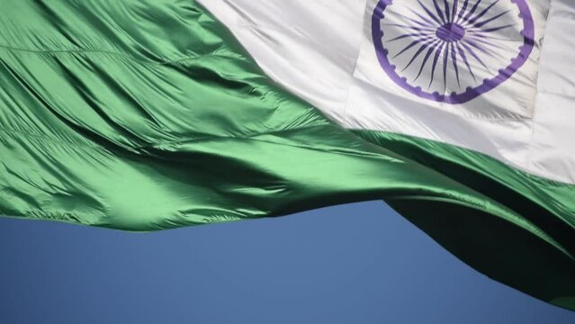 India flag flying high at Connaught Place with pride in blue sky, India flag fluttering, Indian Flag on Independence Day and Republic Day of India, tilt up shot, Waving Indian flag, Har Ghar Tiranga