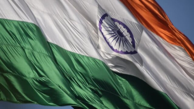 India flag flying high at Connaught Place with pride in blue sky, India flag fluttering, Indian Flag on Independence Day and Republic Day of India, tilt up shot, Waving Indian flag, Har Ghar Tiranga