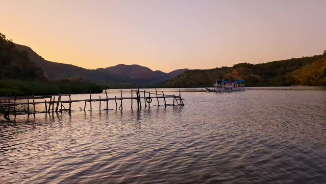 Golden dawn on the sea and mountains with a small wooden pontoon in the Philippines.