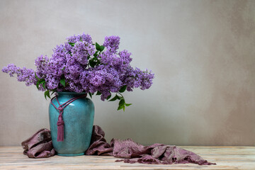 A huge bouquet of lilacs in a large vase isolated on a light  background. Still life with flowers,...
