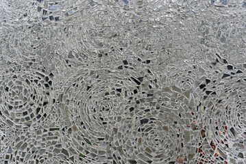 Mirror gray background. Wall with small pieces of mirror