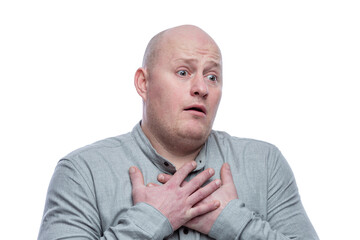A bald man in a gray shirt pressed his hands to his chest in surprise. Isolated on a white background. Close-up.