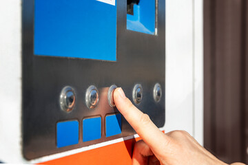 A woman's index finger presses the machine button. Close-up.
