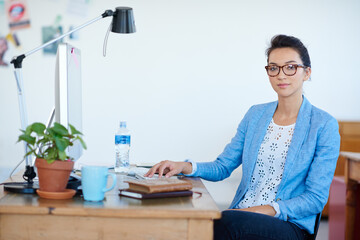 Business woman, confidence and portrait at computer for creative project, planning or copywriting career. Face of a young professional editor, writer or person in glasses at desktop for startup