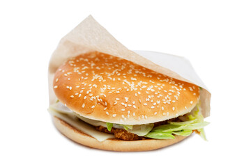 Appetizing burger in craft paper packaging. Delicious garbage food. Isolated on a white background. Close-up.