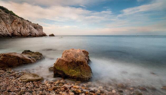 Beautiful sea view with rocks, blue sky and calm water. Long exposure photography.