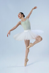 Naklejka premium young Japanese ballerina poses in a photo studio with ballet elements showing stretching and plasticity