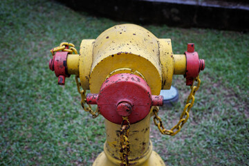 yellow and red standpipe, water supply or fire hydrant system in public park for emergency purposes