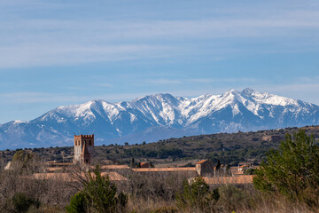 The bell tower of Espira de l'Agly with the snow-covered Canigou