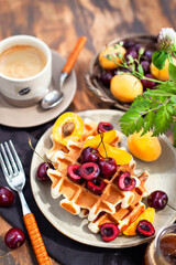 Fresh homemade belgian waffles decorated with cherry, apricot and salted caramel