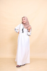 Full body portrait of a beautiful young Asian Muslim woman in a cheerful hijab posing gracefully. for advertising, content, banners and Ramadan