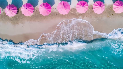 Fototapeten Beach with pink umbrellas, top view, drone photo, sea waves in the background, summer vacation concept © ALL YOU NEED studio