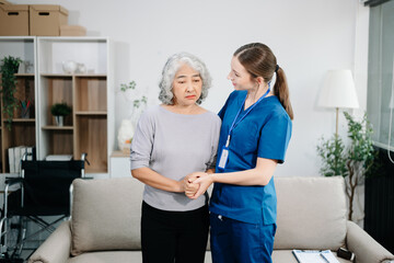 Doctors explain the use of medication to patients. Medical doctor holing senior patient's hands and comforting her on sofa