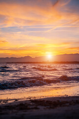 beautiful sunset over calm sea, waves of water and clean sand, Salou, Spain