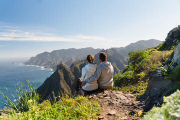 Couple enjoying vacation in nature. Hikers watching beautiful coastal scenery.