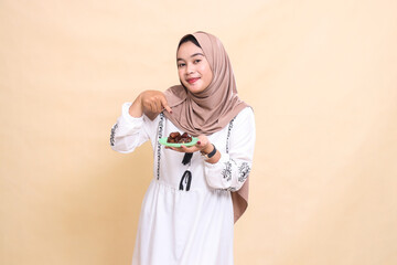 Fototapeta premium a beautiful indonesia Muslim woman wearing a hijab was surprised to bring dates for sahur and breaking the fast. used for advertising, health, Eid and Ramadan