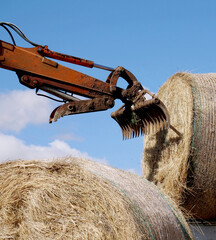 Mechanical arm with rake on hay bale - 768702418