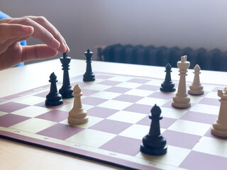 Playing chess.chess board game.Child playing chess and moving a piece in school environment