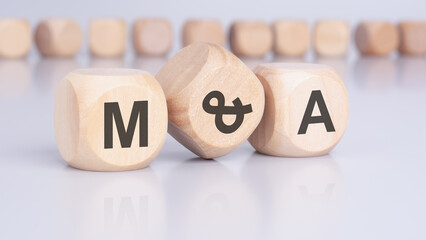 text 'M and A' - Mergers and Acquisitions - on wooden cubes