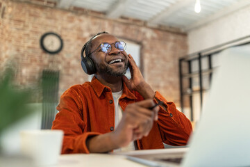 African american man in eyeglasses and headphones looking contented