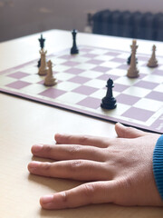 Playing chess.chess board game.Child playing chess and moving a piece in school environment