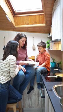 Two mothers and their son eating homemade pancakes together in the kitchen at home