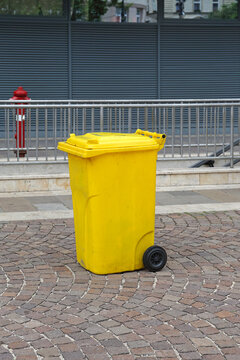 Yellow Plastic Wheelie Bin at Cobblestone Street in City