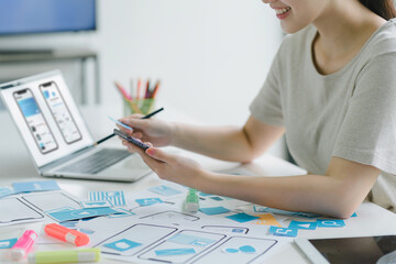 Creative ux ui designers team developing wireframe and sketching layout design mockup on smartphone...