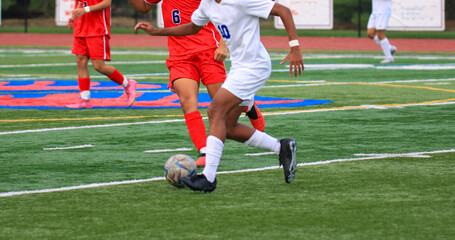 Soccer player dribbling the ball past a defender during a game