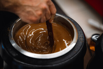 Close up of melted chocolate in a large bowl with a whisk for mixing. A bio homemade hot chocolate...