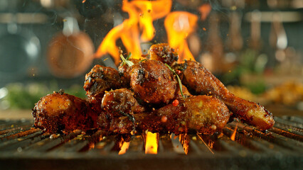 Close-up of tasty chicken legs on cast-iron grate with fire flames - 768736689