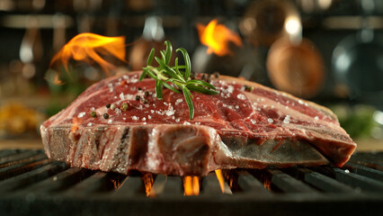 Close-up of tasty raw beef steak on cast-iron grate with fire flames
