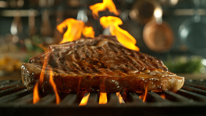 Close-up of tasty raw beef steak on cast-iron grate with fire flames - 768737466