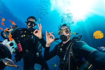 Scuba Divers Swimming in Deep Sea With Sunrays. Young Man DIver Eploring Sea Life. - 768738249
