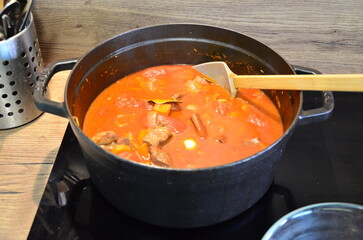 red soup, the sauce is cooked on an induction stove